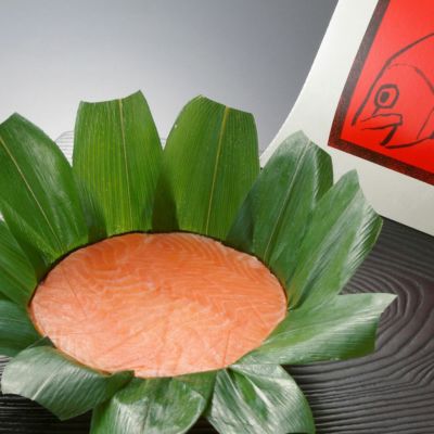 富山名産品ますのすしの笹が開かれ、鱒の身が美味しそうに見えています。