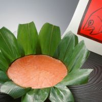 富山名産品ますのすしの笹が開かれ、鱒の身が美味しそうに見えています。