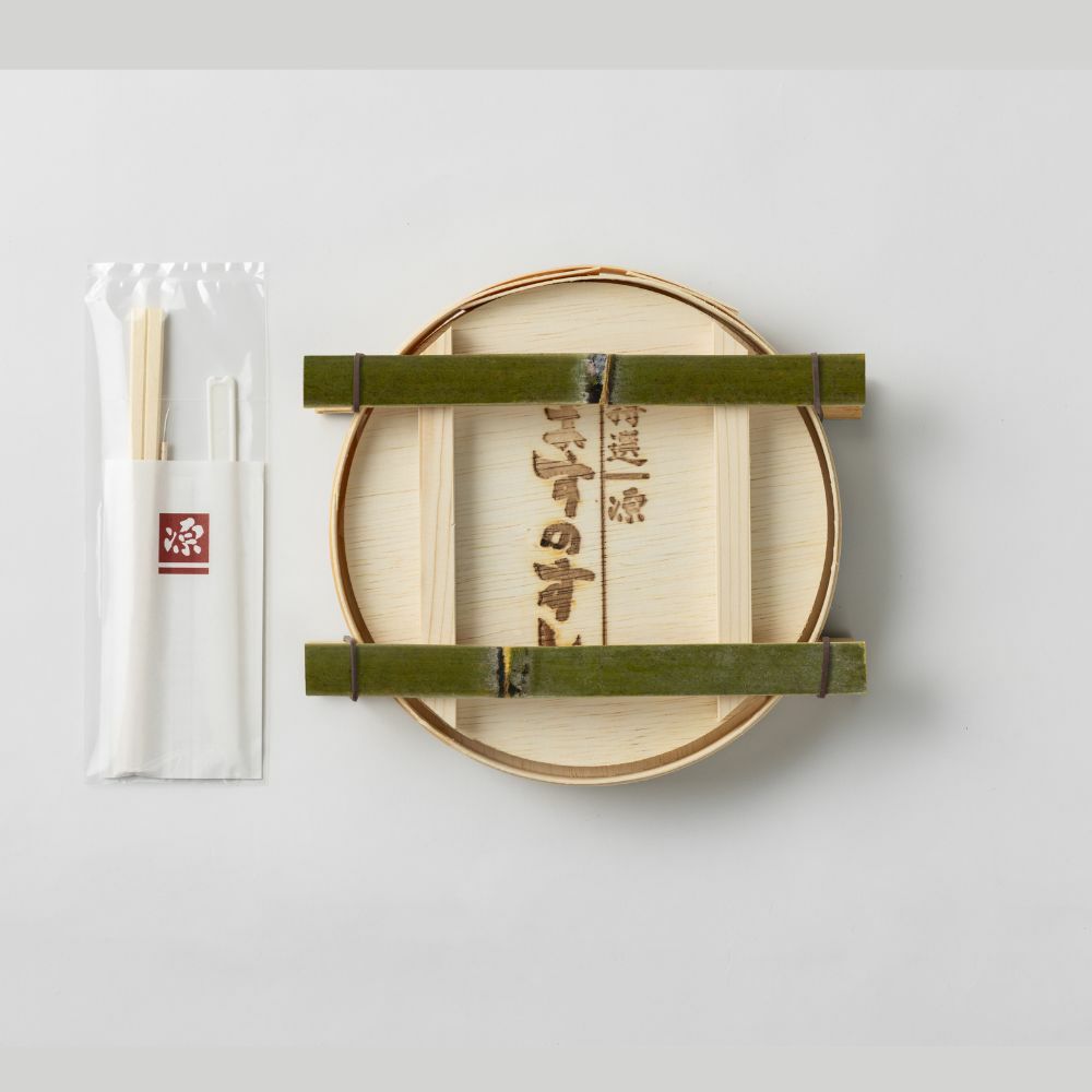 鱒寿司の内容物画像。曲げ物と箸、ナイフなどが載っています。