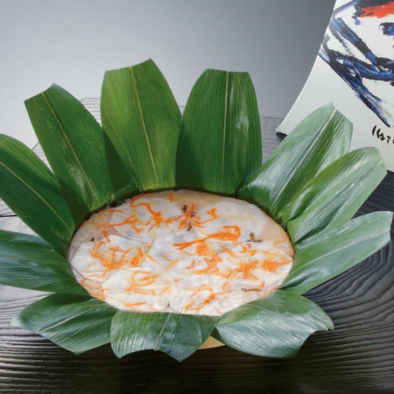 ぶりのすしの笹が開かれ、鰤の身と人参やかぶらなどが美味しそうに見えています。