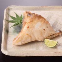 魚の部位の中でも味が濃く美味とされる大きなぶりのかまを柔らかく煮込み味を付けた「ぶりかまうま煮」の皿盛イメージ画像です。