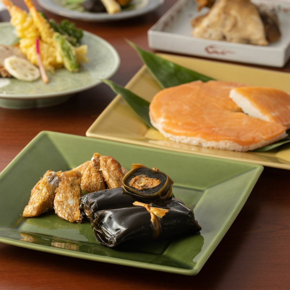 ますのすし一重とうま煮２種類がお皿に盛りつけられた食卓のイメージ画像です。